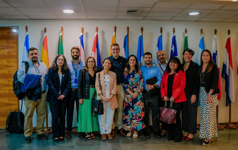 Grupo de personas posando frente a banderas de varios países